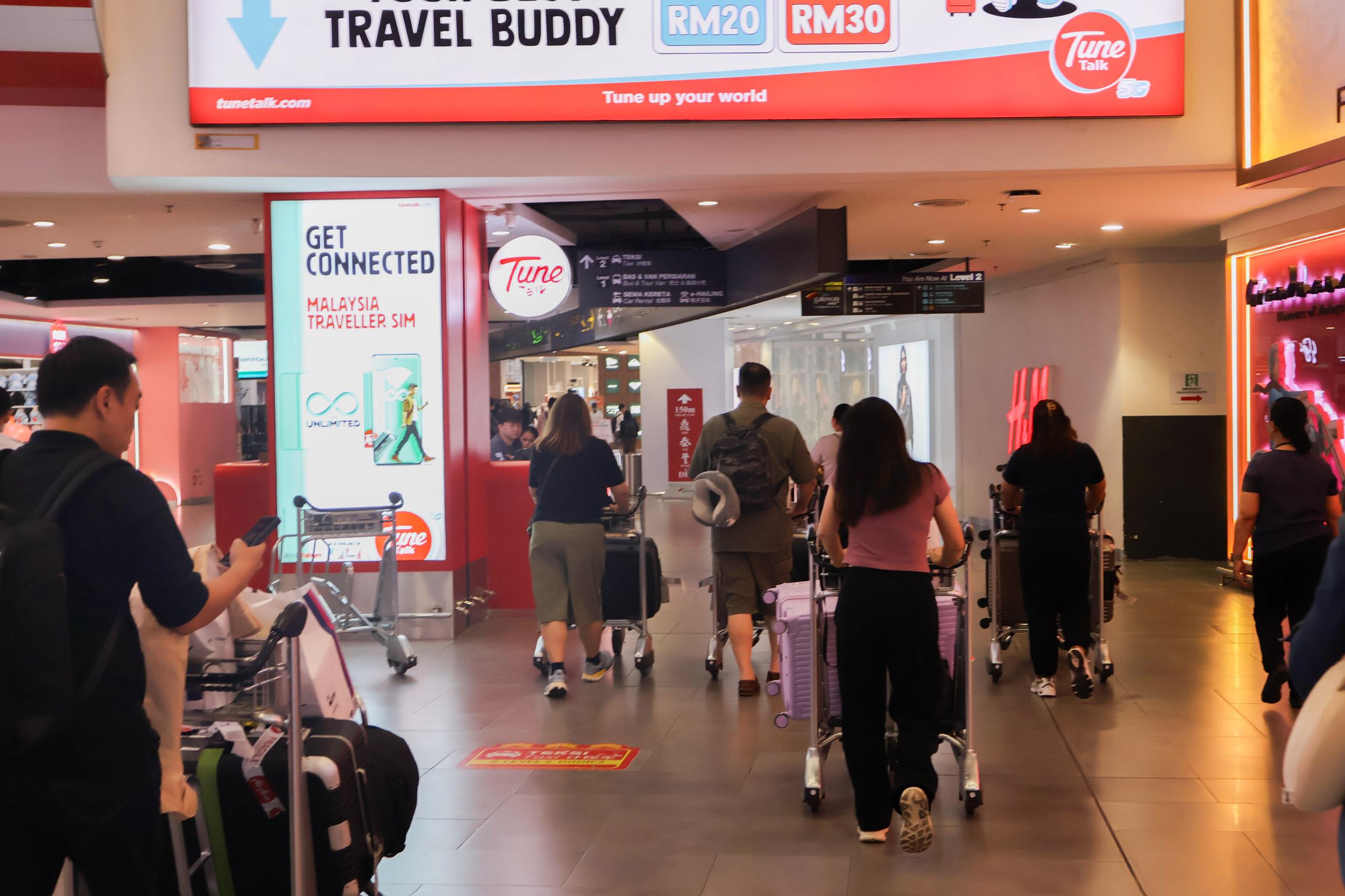 KLIA Terminal 2 arrival walkway with SIM card shop nearby